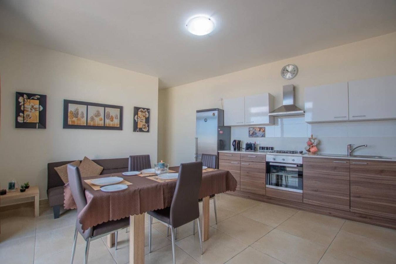 A compact living space with a dining area, kitchenette, and a sofa.