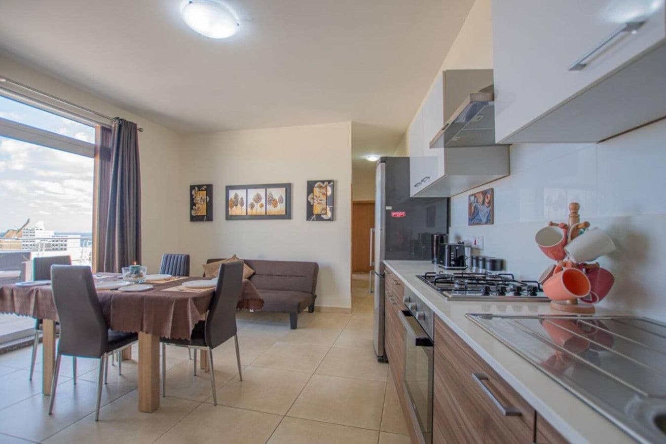 Una cocina moderna con comedor, un sofá y obras de arte en las paredes.