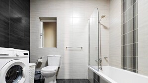 Un baño moderno con lavadora, inodoro y bañera.