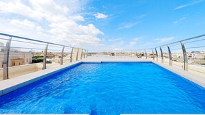 Una piscina en la azotea con vista despejada al paisaje urbano.
