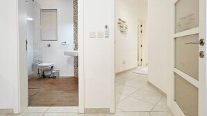 Un baño moderno con ducha, inodoro y lavamanos.
