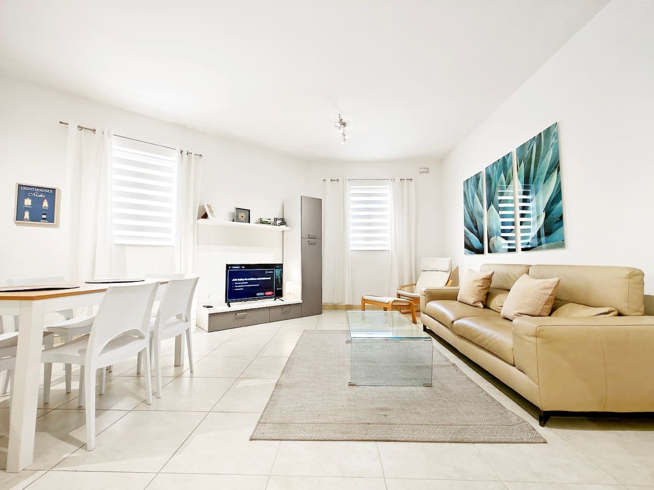 A modern living room with a sofa, a coffee table, and a TV.