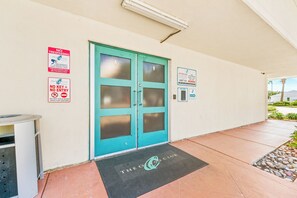 A building entrance with a turquoise door, a 'NO TRESPASSING' sign, and a 'NO KEY = NO ENTRY' sign. - Ocean Club 1005 Enjoy Panoramic Views of the Gulf! (Biloxi)