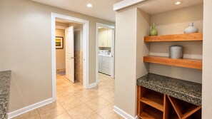 A hallway with a kitchen area visible through an open door, featuring cabinets and a countertop. - Ocean Club 1005 Enjoy Panoramic Views of the Gulf! (Biloxi)