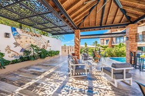 Eine Außenpatio mit Pool, Sitzbereich und einer Zierwand.