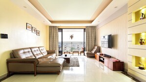 A modern living room with a sofa set, a coffee table, a TV, and a balcony with a view. - Crestpark Penthouse Spectacular Views (Nairobi)