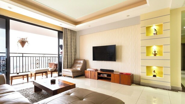 A modern living room with a large sofa, a flat-screen TV, and a balcony with a view. - Crestpark Penthouse Spectacular Views (Nairobi)