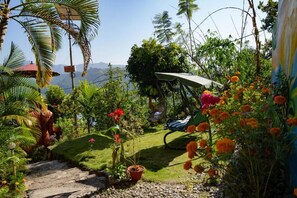 Un jardín con un sendero, una silla y vistas del paisaje.