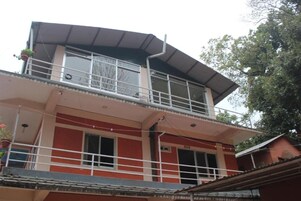 Un edificio de dos plantas con un balcón en el piso superior.