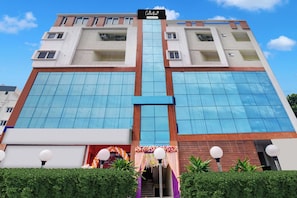 Un edificio de varios pisos con un atrio central, ventanas amplias y un letrero que indica que es un lugar de servicios para empresas.