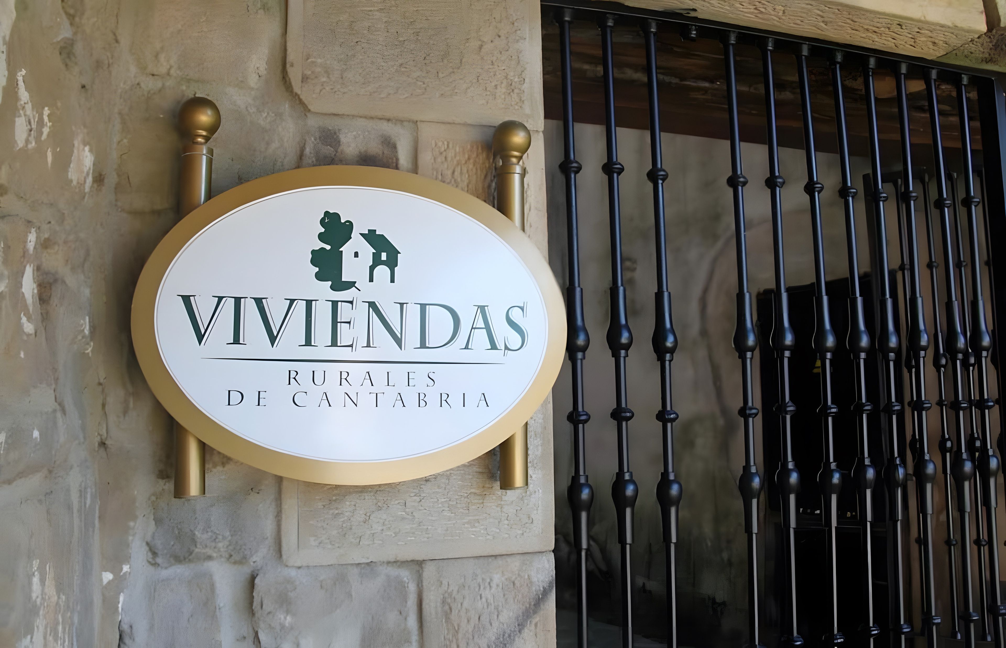 Señalización para 'Viviendas Rurales de Cantabria', con un icono de casa y una verja metálica al fondo.