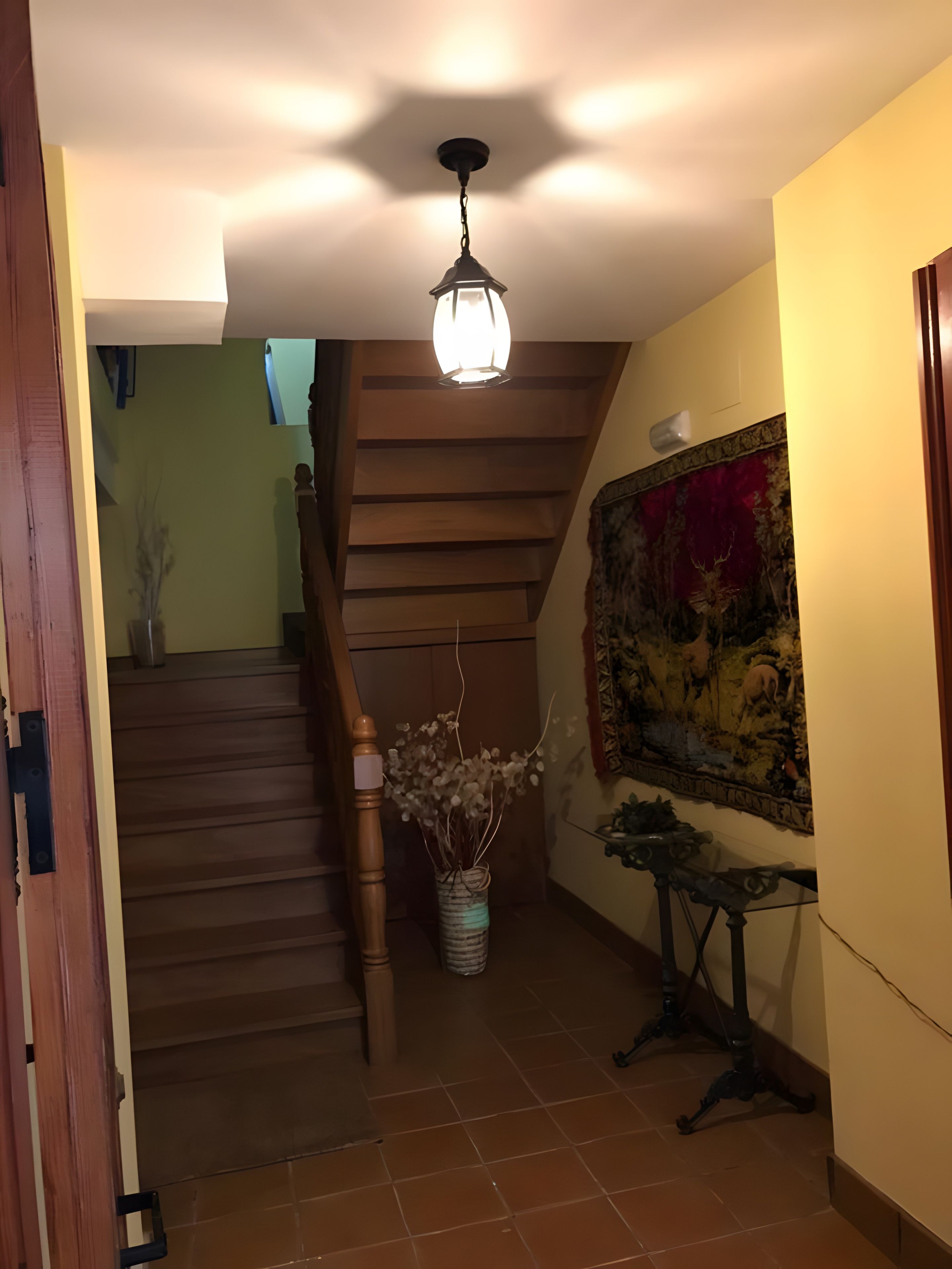 Una escalera con escalones de madera y una lámpara colgante.