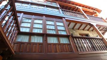 Een meerlaags gebouw met een balkon en grote ramen.