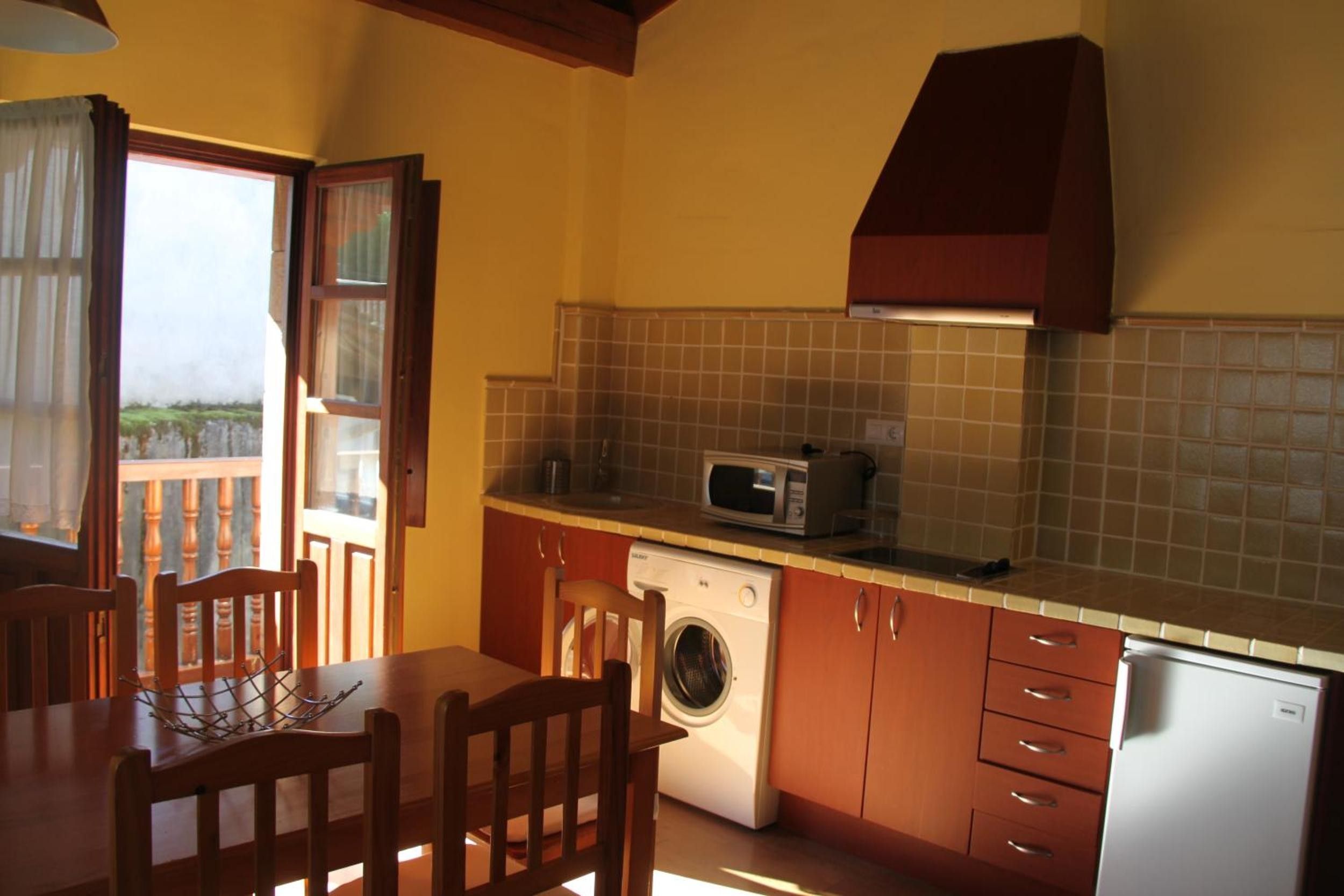 A compact kitchen with a washing machine, a microwave, and a sink.