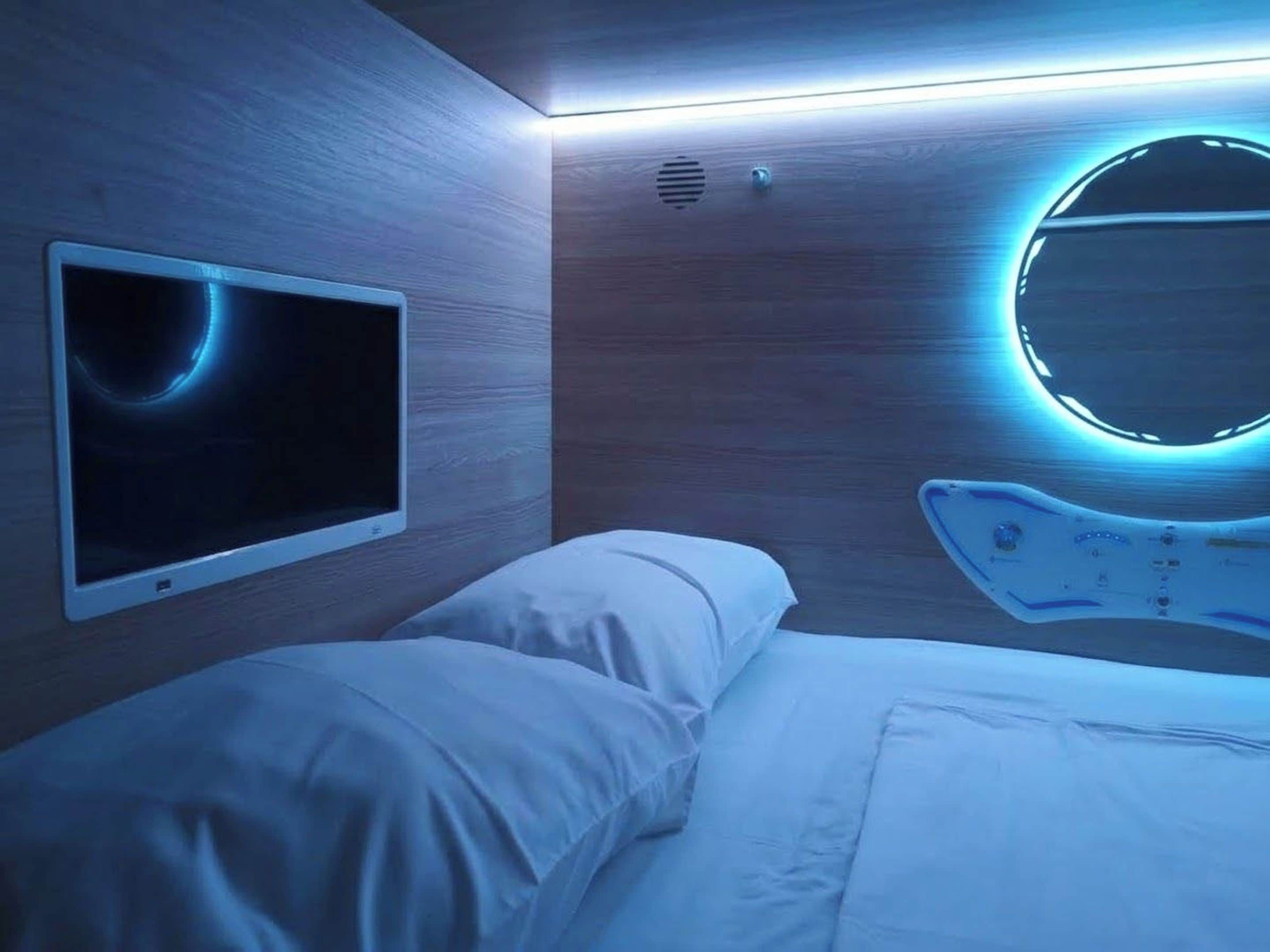 Een moderne kamer met een bed, een wandtelevisie en een ronde lamp.