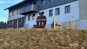 A two-story building with a sign reading 'Apfel Stadt 11' and a balcony on the upper floor. - Vrbo Property (Oberreute)