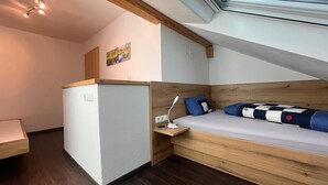 A compact room with a bed, a small desk, and a window. - Vrbo Property (Oberreute)