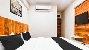 A hotel room with a bed, a mounted TV, an air conditioning unit, and a wooden accent wall. - Collection O Indore Gandhi Hall (Indore)