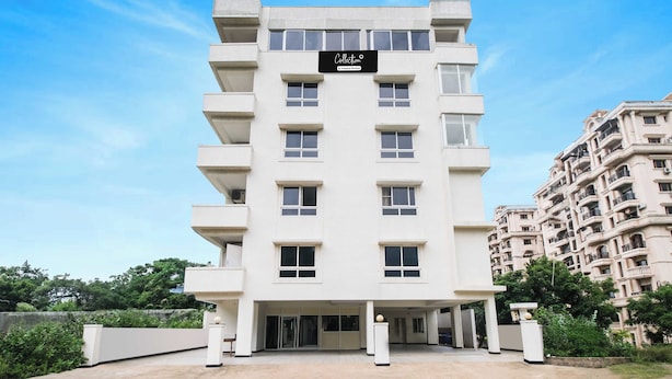 A multi-story building with a sign indicating it's a company-serviced collection. - Collection Rushikonda Beach Near GITAM (Visakhapatnam)