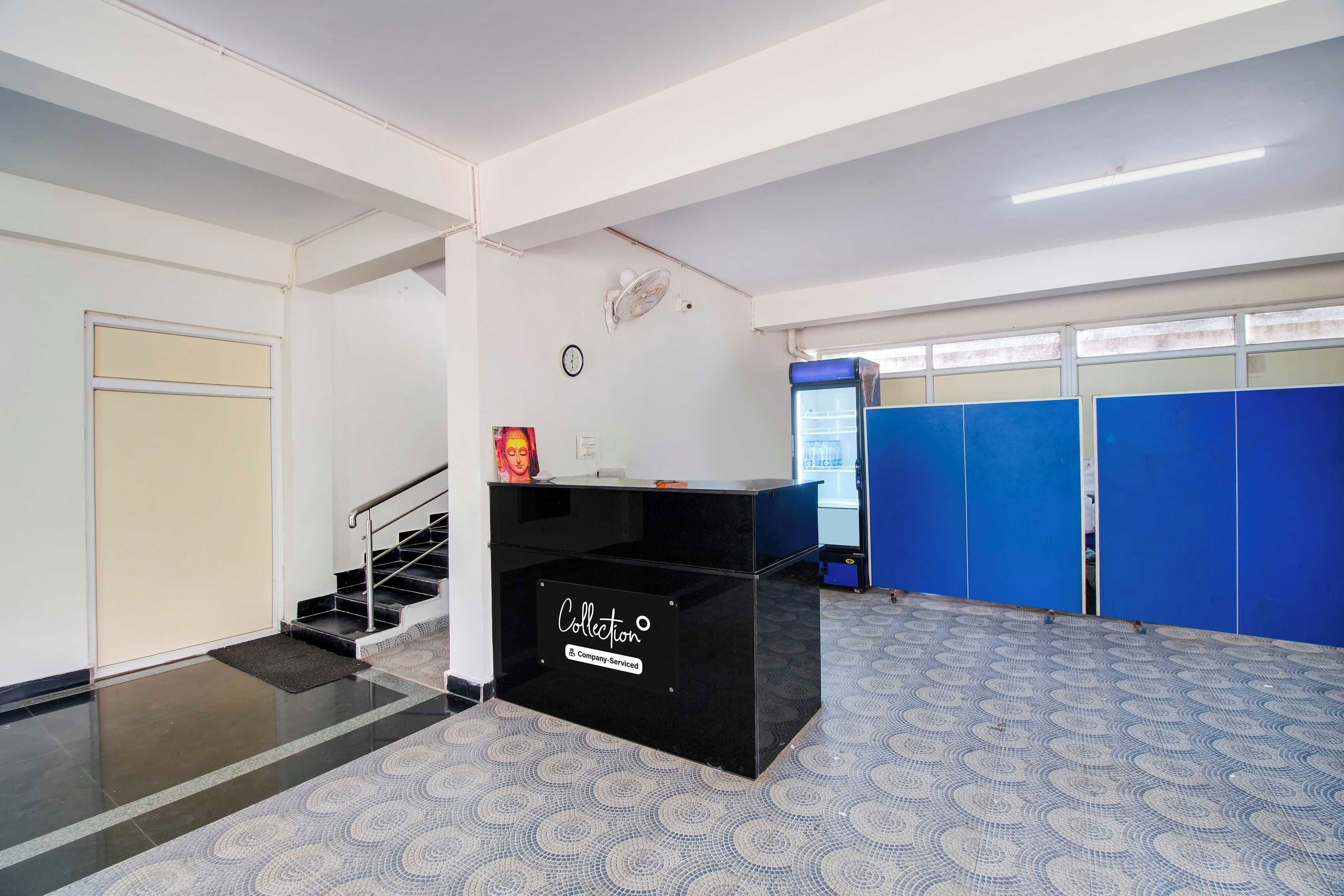 A reception area with a black counter, a clock, and a blue locker room in the background.