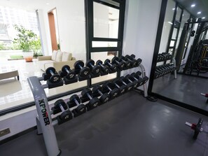 Ein Fitnessraum mit einer Hantelbank und einer Reihe von Kurzhanteln.