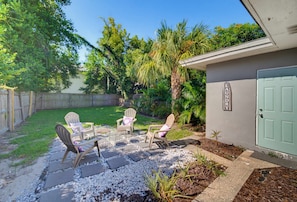 A patio with outdoor furniture and a house with a green door. - Fenced Backyard 2BR Pet Friendly and Sleeps 6 (Clearwater)