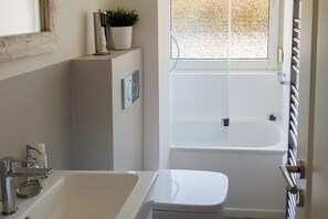 Ein Badezimmer mit einer Badewanne, einem Waschbecken und einer Toilette.