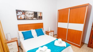 Ein Hotelzimmer mit einem Bett, einem Nachttisch, einem Kleiderschrank und einem Wandbild.