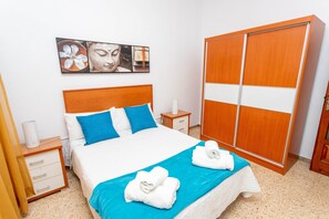 Une chambre d’hôtel comprenant un lit, une table de chevet, une armoire et une œuvre d’art murale.