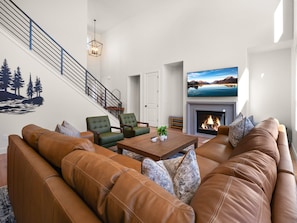 A modern living room with a fireplace, leather sofas, and a large flat-screen TV. - Wasatch Lodge: Sleeps 16, Sauna/HotTub, Pool Table (Heber City)