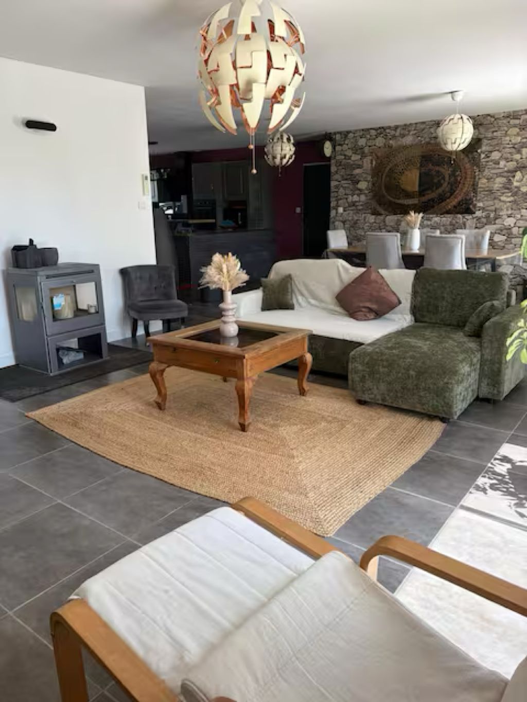 Een woonkamer met een bank, fauteuils, een salontafel en decoratieve lampen.