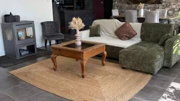 Een woonkamer met een bank, fauteuils, een salontafel en decoratieve lampen.