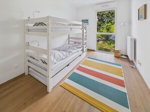 A bunk bed room with a view of greenery outside. - Fouesnant, accessible apt near beach & parking (Fouesnant)