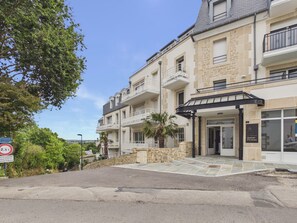A multi-story hotel with a stone facade, balconies, and a covered entrance. - Fouesnant, accessible apt near beach & parking (Fouesnant)
