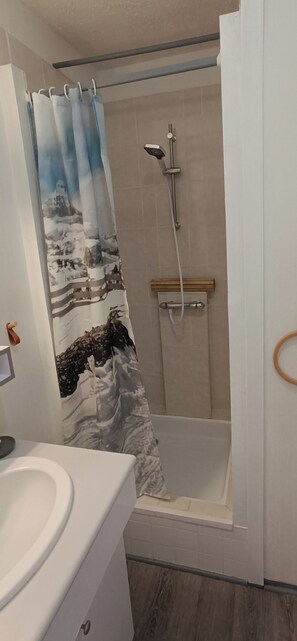 Ein Badezimmer mit Dusche, Toilette und Waschbecken.