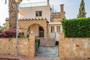A two-story building with a stone facade, a central archway, and a staircase leading to the upper level. - Spacious 5-bedroom house with AC in lovely Poli Chrysochous (Poli Chrysochous)