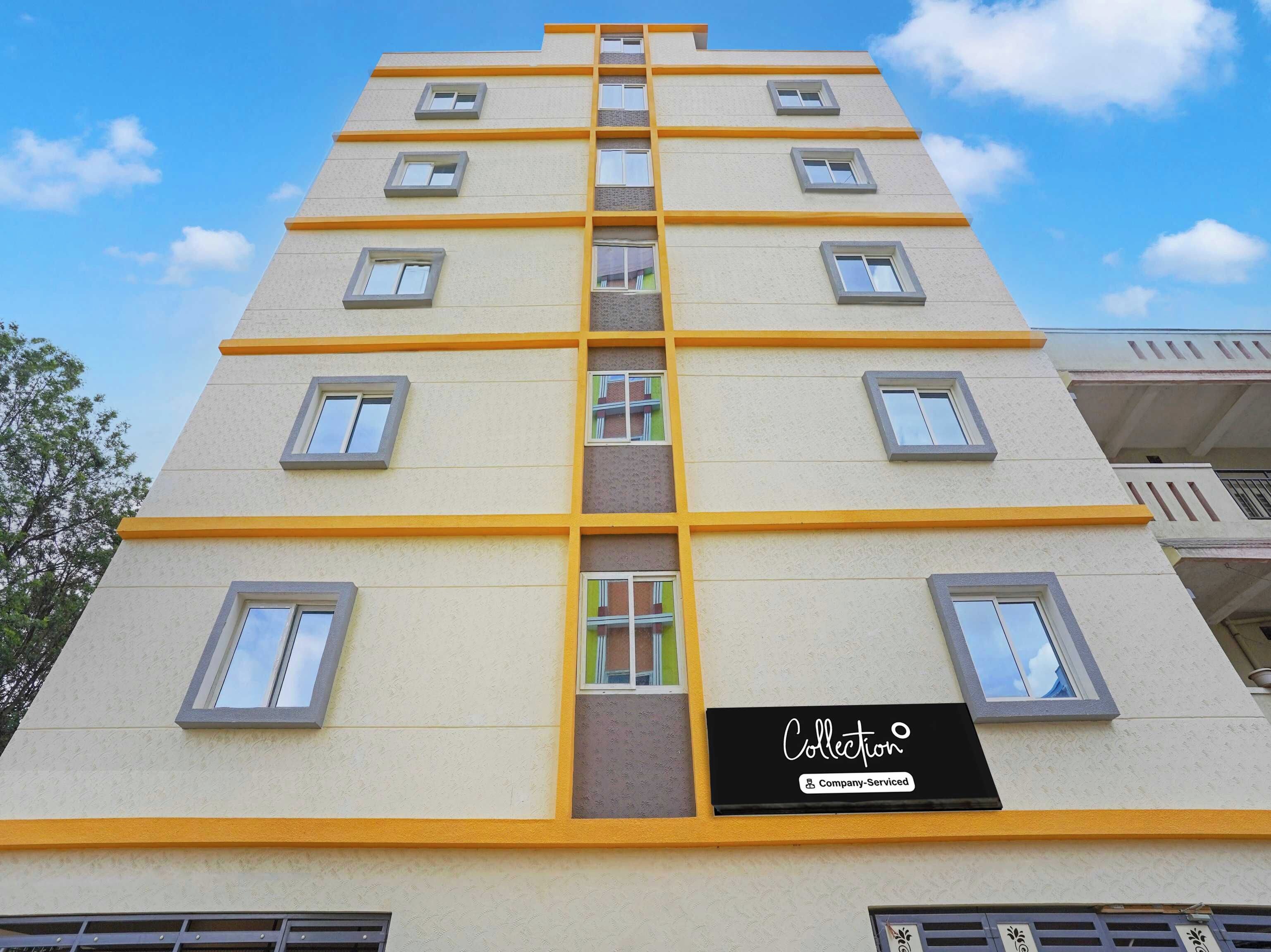 A multi-story building with a central staircase, multiple windows, and a sign indicating 'Collection Company-Serviced'.