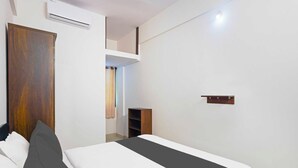 Una camera da letto con un letto, un armadio, uno scaffale e un condizionatore d'aria.