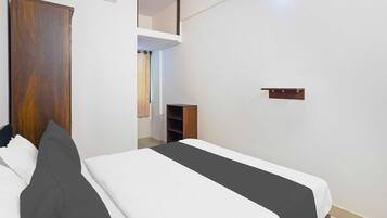Un dormitorio con cama, armario, estante y unidad de aire acondicionado.