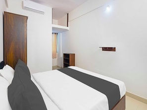 A bedroom with a bed, a wardrobe, a shelf, and an air conditioning unit. - Collection O Karmelaram Railway Station (Bengaluru)