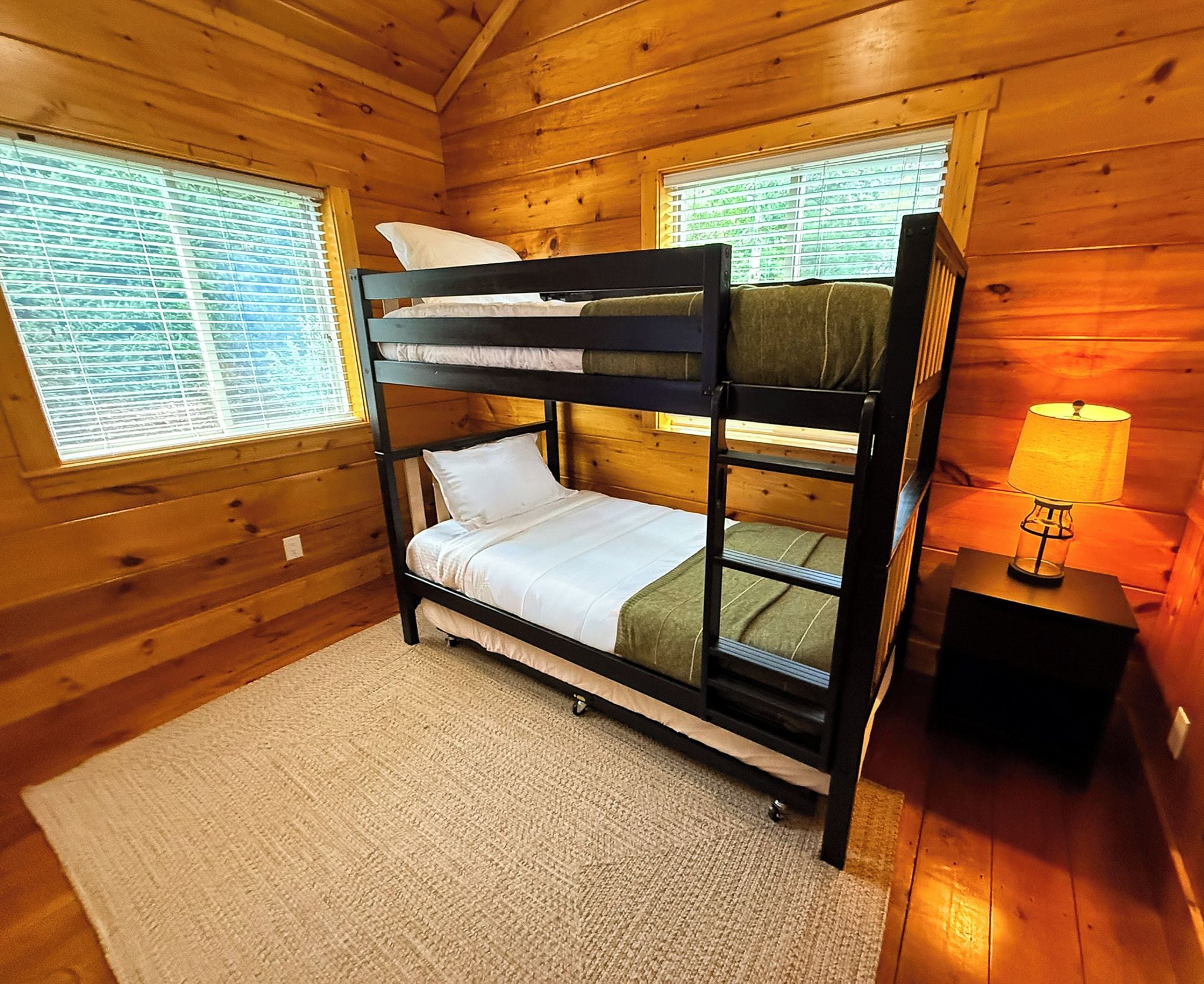A bunk bed room with a window and a lamp.