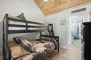 Ein Etagenbett mit einer Leiter, eine Tür mit dem Schild 'Willkommen im Zoo' und ein Bild an der Wand.