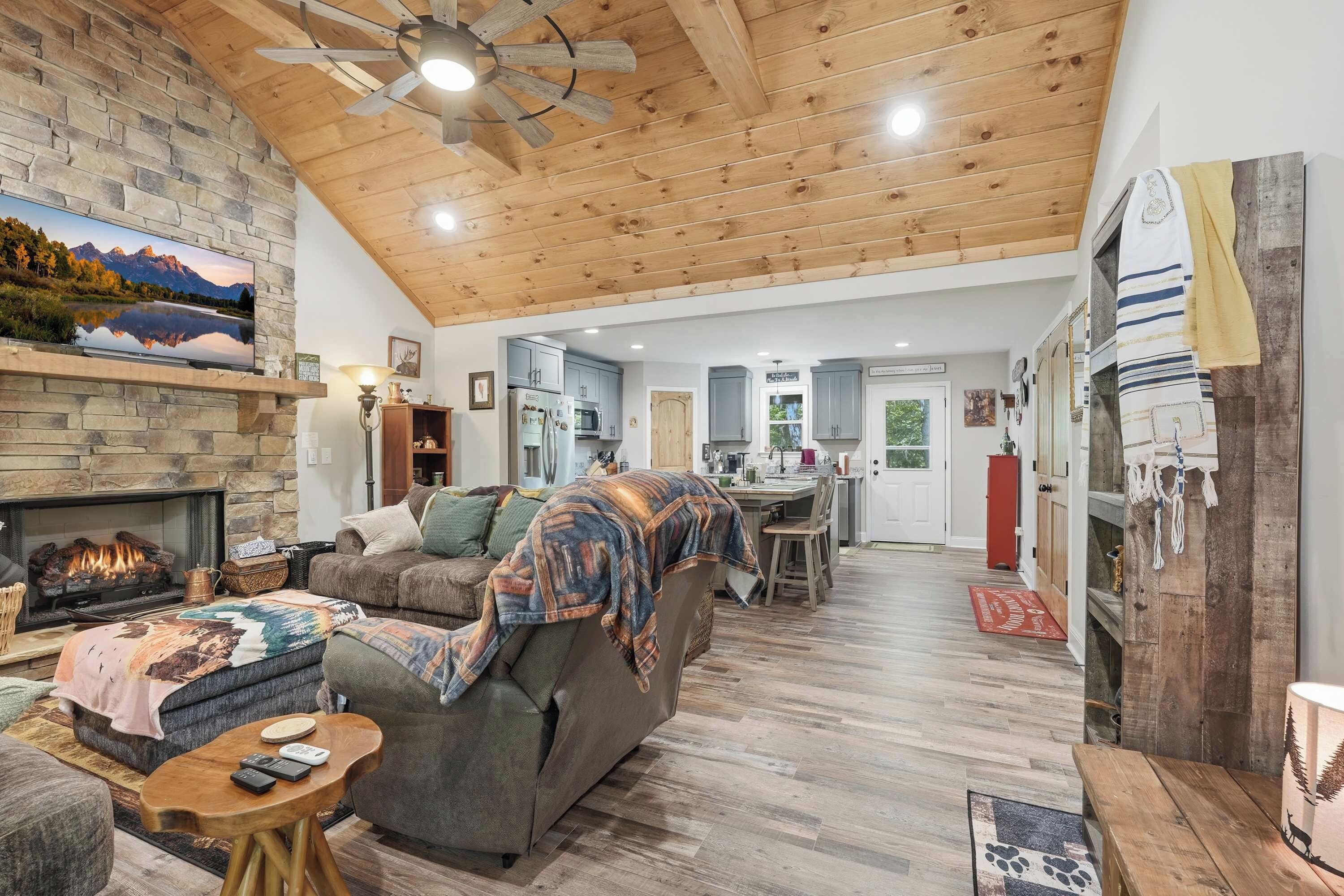 A spacious living room with a fireplace, a sofa, a coffee table, and a television.