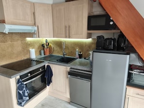 A compact kitchen with a microwave, stove, sink, and dishwasher. - Holiday Home 'Le Cottage Des Dunes - Erdeven' with Private Terrace, Garden and Wi-Fi (Erdeven)
