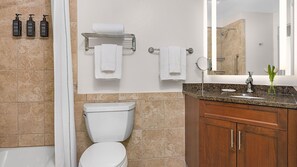 Ein Badezimmer mit Toilette, Waschbecken, Spiegel und Dusche.