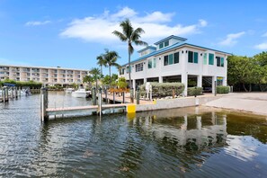A waterfront hotel with a dock, boats, and a clear sky. - Key Lime Sunrise Top Floor Oceanfront 3404 (Tavernier)