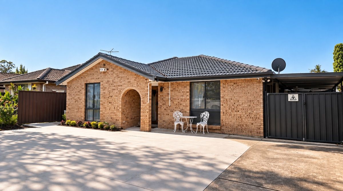 A residential building with a brick facade, a tiled roof, and a gated entrance.