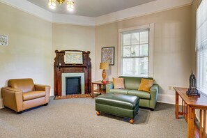 A living room with a fireplace, a sofa, a chair, and a lamp. - Walk to Decatur Square! Spacious Home w/ Porch (Decatur)