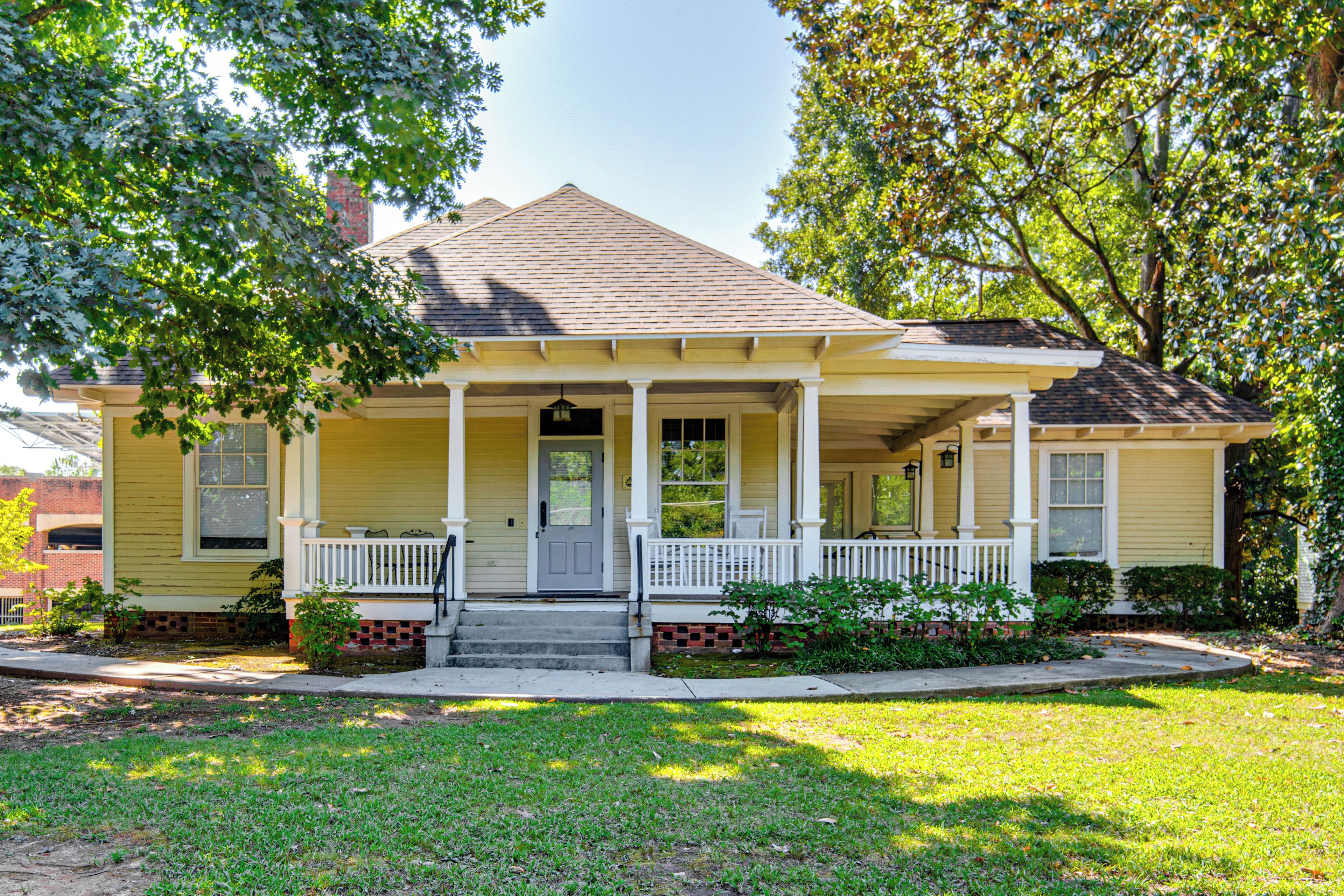 A two-story house with a front porch, a chimney, and a well-maintained lawn.