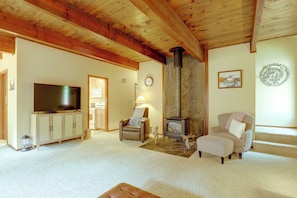 Ein gemütliches Wohnzimmer mit Fernseher, Kamin und bequemen Sitzmöglichkeiten.
